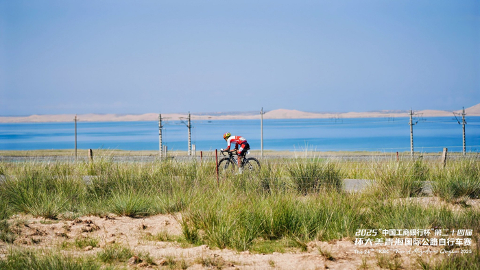 图为领先选手破风前行，在美景的掩映下享受这段孤独的冲刺旅程。