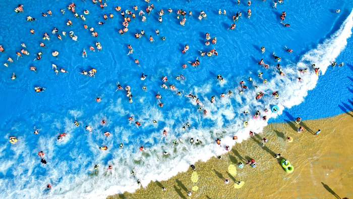 7月5日，浙江省湖州市长兴县太湖图影旅游度假区龙之梦乐园嬉水世界，游客亲水消暑（无人机照片）。新华社发（吴拯 摄）