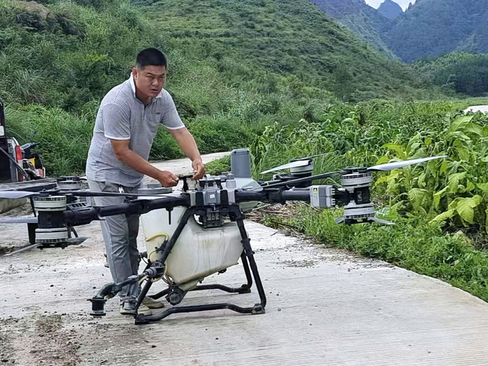专业化服务队员在给无人机添加药剂。唐明奎摄