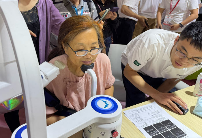 6月11日，一名参观者在博览会上体验颈动脉筛查机器人。新华社记者 黄安琪 摄