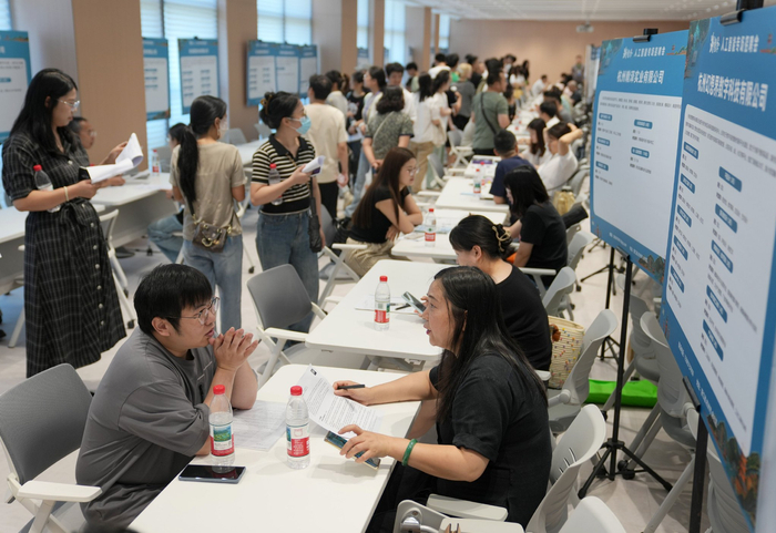 6月28日，求职者与招聘代表在2025年杭州市人工智能专场招聘会上洽谈。新华社记者 韩传号 摄
