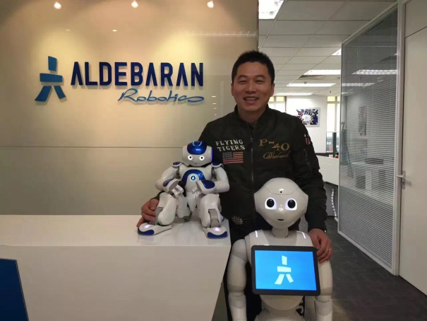 （齐建伟在Aldebaran Robotics与Nao、Pepper机器人的合影）