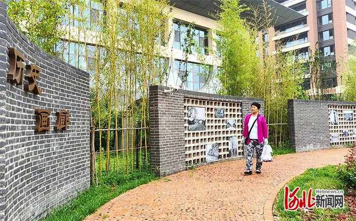 7月14日，在廊坊市“梦回廊园”打卡点，市民正在观看墙上的老照片。河北日报记者 刘英摄