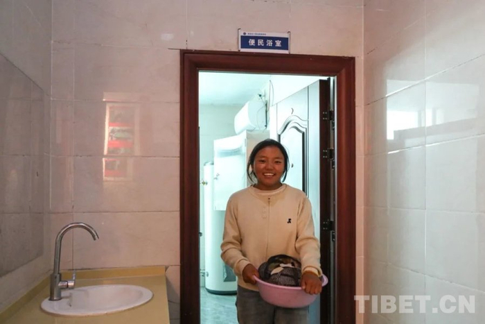 图为当地孩子在便民浴室门口露出开心的笑容