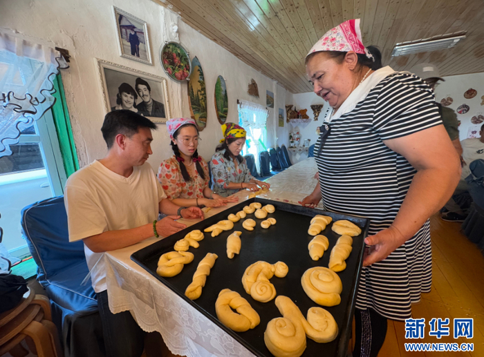 孙金花教游客制作列巴。新华网 李倩 摄