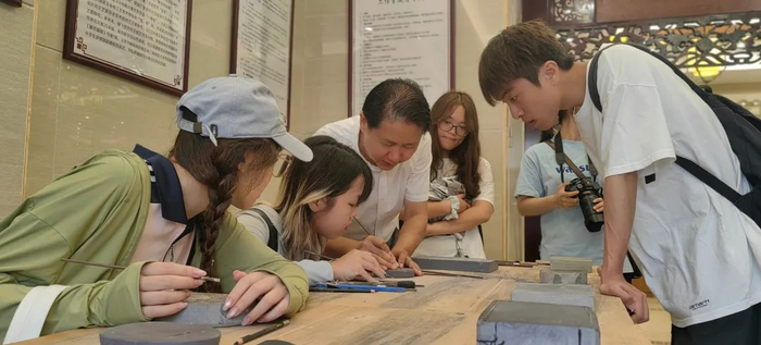 △清华美院学子体验端砚雕刻。 通讯员 梁学俭 摄
