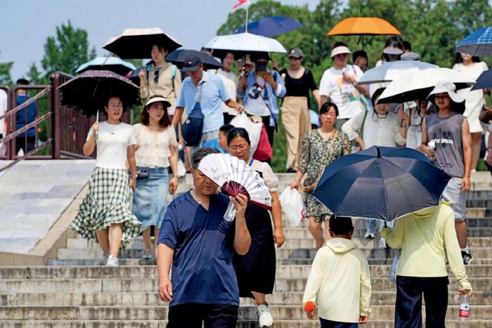 2025年7月12日，北京持续高温，游客热情不减，在天坛公园游玩。