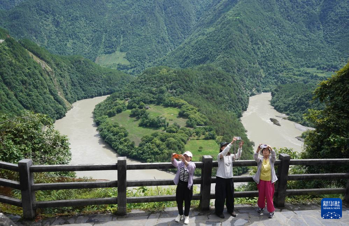 7月15日，游客在云南省怒江傈僳族自治州贡山独龙族怒族自治县怒江第一湾拍照游玩。新华社发（梁志强摄）