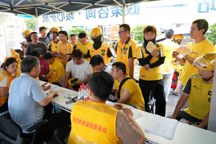 ▲7月初，广东深圳美团骑手在街头服务站向人社部门工作人员咨询养老保险参保流程。（摄影：林书明）