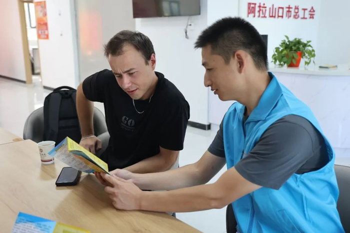 “金色丝路”国际志愿服务项目志愿者为外籍司机介绍跨境运输便利服务。刘丽娜摄