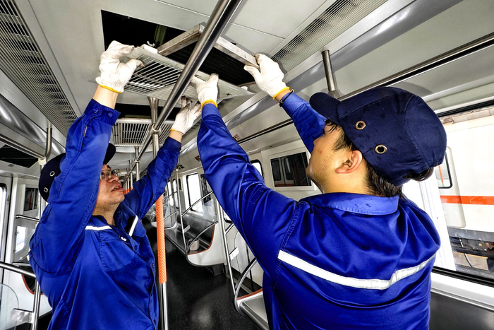 地铁7号线检修人员更换列车客室空调滤网。 通讯员方正阳摄