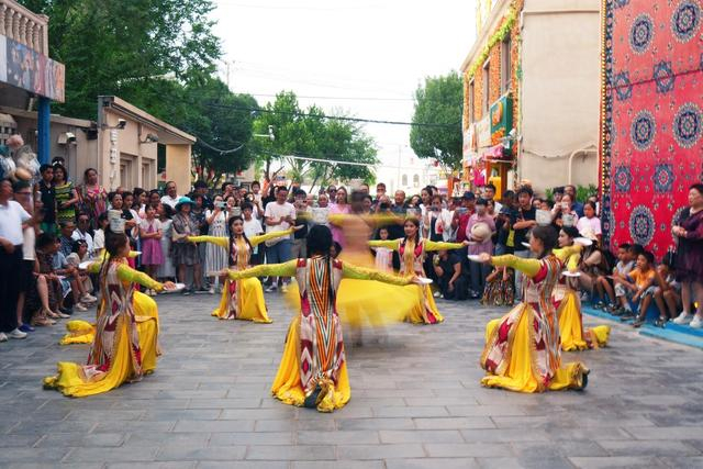 游客在新疆库车市龟兹小巷观看乐舞表演（7月17日摄）。新华社记者 张可任 摄