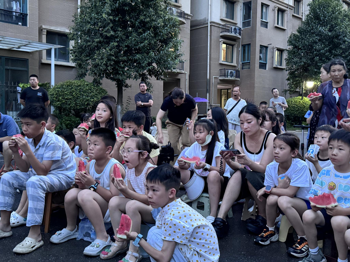 碧桂园龙阳1号小区，小朋友边看露天电影，边吃西瓜。长江日报记者冷靖华摄
