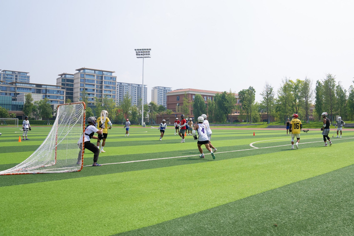 成都大学棍网球队在绿茵场上训练。