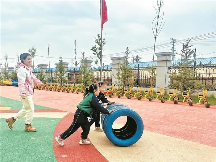 藏城幼儿园内小朋友在操场玩游戏。王晶 摄