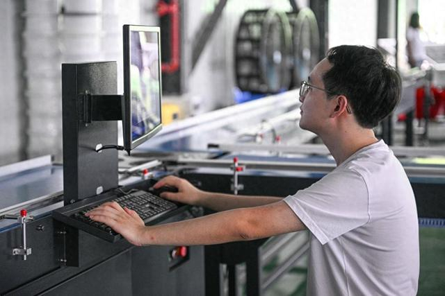 7月18日，在位于海南三亚的海南省优旗农业有限公司榴莲加工厂，工作人员调试榴莲智能分选生产线。新华社记者 蒲晓旭 摄