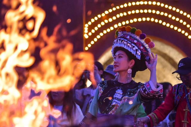 7月18日，一名身着彝族服饰的游客在巍山县拱辰楼广场体验彝族打歌。新华社记者 彭奕凯 摄