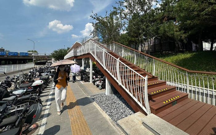 海淀区西钓鱼台地铁站C口外新建一座架空栈桥，实现上下行客流分离，并利用栈桥桥下空间新增非机动车车位。新京报记者 裴剑飞 摄