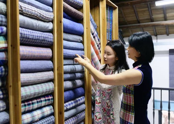 母亲周勤（右）与周雨昕在整理布料。