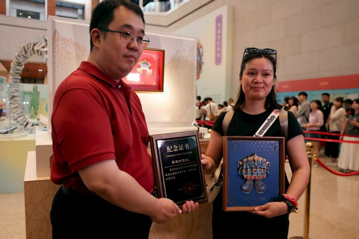中国国家博物馆文创负责人廖飞向罗莉女士颁发纪念证书。新京报记者 浦峰 摄