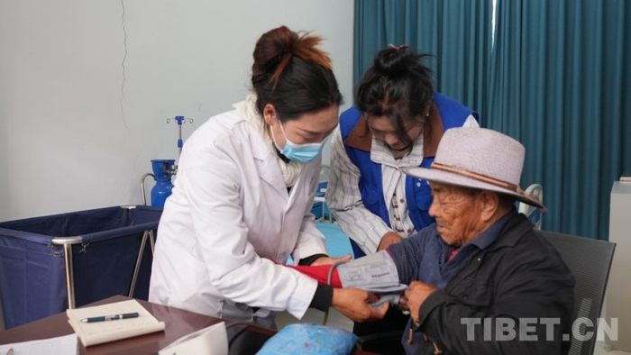 　　图为村医德庆拉姆为老人测量血压
