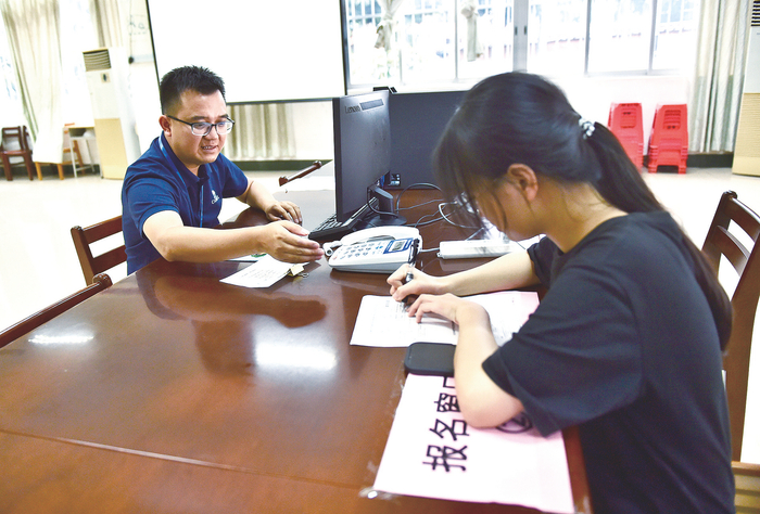     考生在人工窗口进行报名。    本报记者潘浩 摄