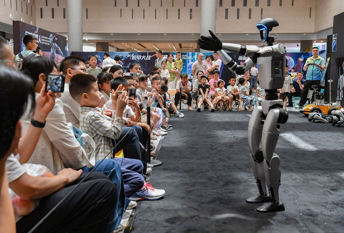 7月6日，浙江省金华市金华之光文化广场科技馆内，人形机器人与观众互动。新华社发（时宽兵　摄）
