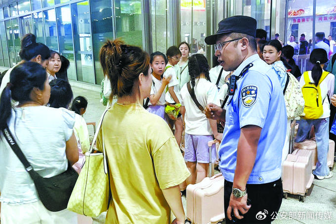 7月18日，包头铁路公安处临河站派出所民警帮助滞留旅客安全转运。 赵旭东 摄