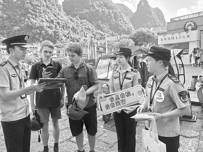 桂林市市场监管部门工作人员向游客介绍食品安全“你点我检”活动详细内容。□苏俊华/摄
