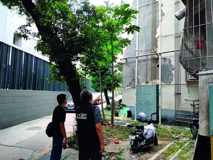 深圳罗湖区黄贝街道工作人员查看墙皮脱落的老楼。图/受访者提供