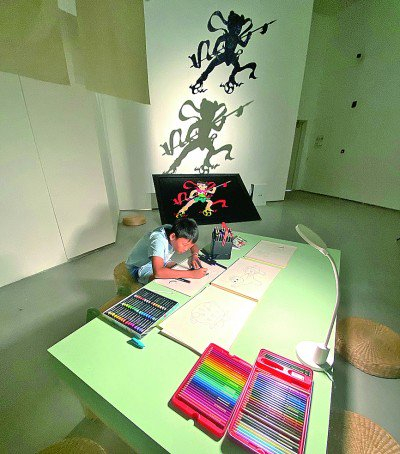     小观众在《哪吒闹海》的布景中认真临摹原稿  本报记者 田呢摄/光明图片