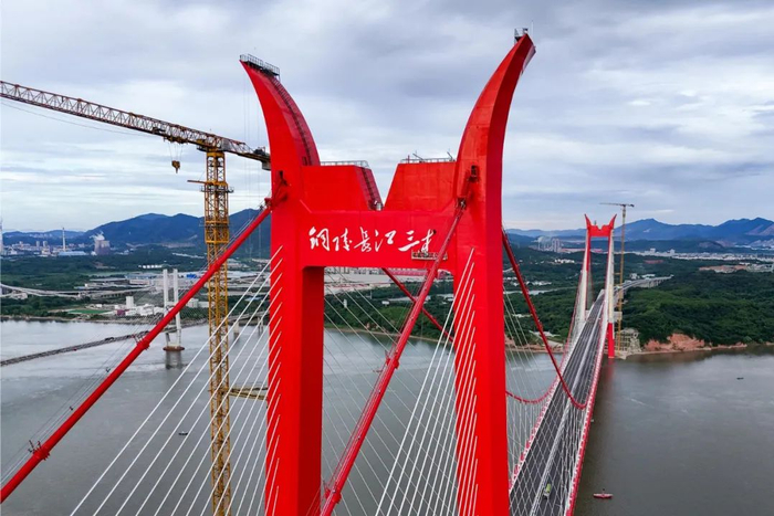     工作人员正在安装桥名标识。储著传 摄