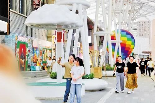 7月18日，游客在唐山市路南区建国里商业街区游玩。河北日报记者 师源 摄