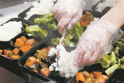 厨房工作人员用塑料餐盒分装饭菜。 新华社发（郝源摄）