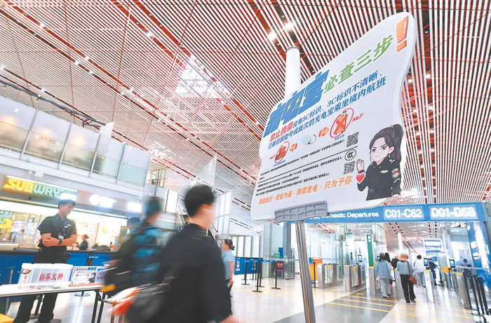 首都机场通过展板等方式向旅客介绍充电宝乘机规定。本报记者 程功摄