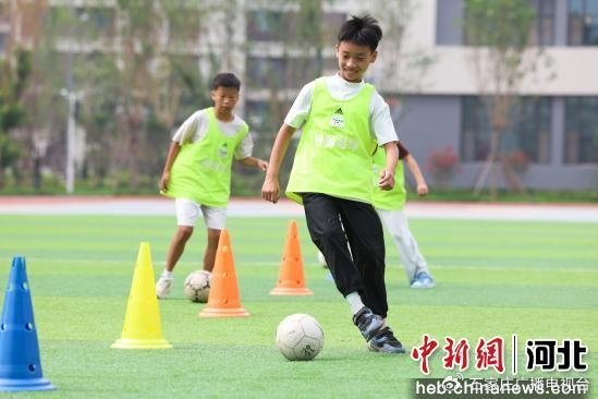 图为参加暑期托管服务的学生在练习足球基本功。  赵元君 摄