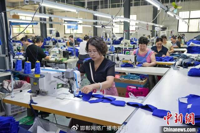 图为7月15日，河北弘润服饰有限公司的工人正在赶制来自海外的订单。 　 杜昕雨 摄　