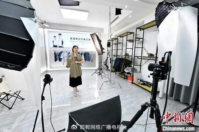 图为7月14日，邯郸市森尚依品服装有限公司的员工正在直播带货。 杜昕雨 摄