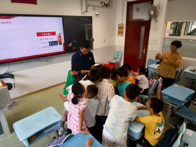 图说：马桥站至马桥实验学校开展暑期消防安全宣讲，并讲解灭火器的使用方法。