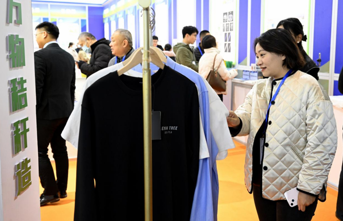 在第三届国际新材料产业大会展览上，观众在参观由秸秆加工制作成的衣服。新华社记者 黄博涵 摄
