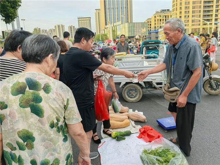 市民正在南湖早市选购蔬菜。