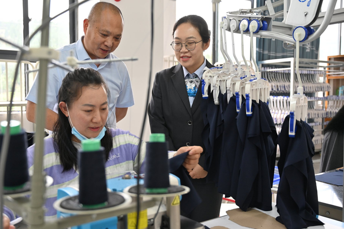 农行越西支行工作人员走进越荣服装，了解企业生产经营和资金需求。吕双虎/摄