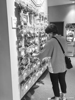 “协和时光身心空间”店铺里一名女士正在挑选器官挂件