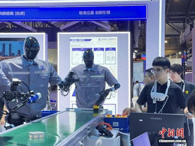 7月25日，记者提前探馆，现场工作人员正在调试人形机器人。中新网记者 郑莹莹 摄