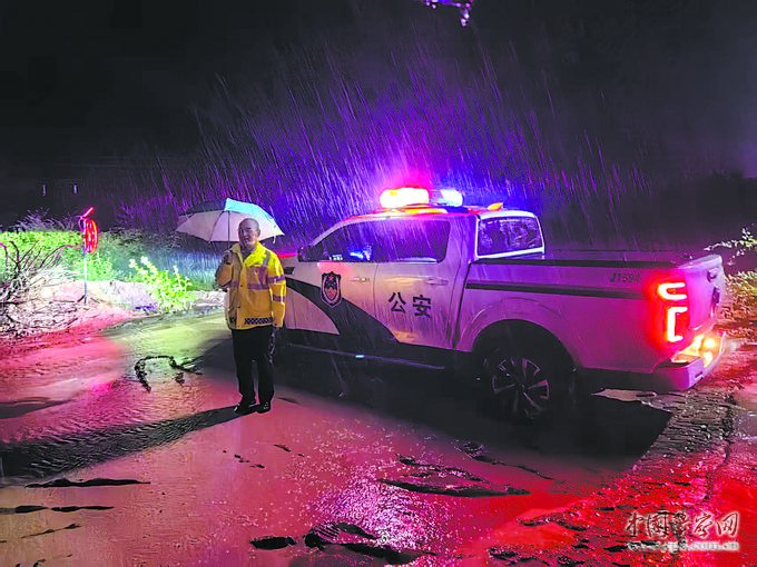 7月25日，吴起县公安局民警冒雨在道路上执勤。