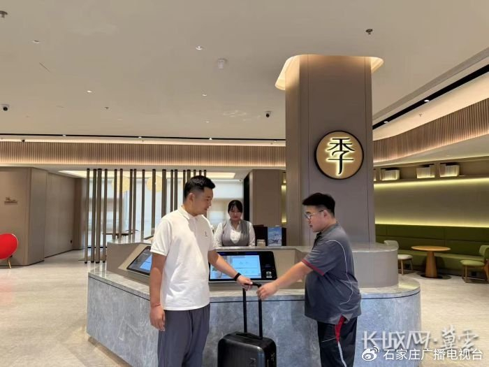 河北顺丰速运工作人员（右）到酒店收取外地游客要寄送的行李。