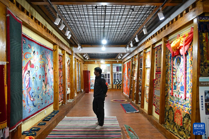 7月18日，一名参观者在江孜藏毯文化发展有限责任公司的展示厅内观看藏毯产品。