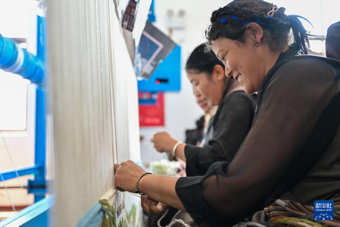 7月18日，江孜藏毯文化发展有限责任公司的员工在生产车间内编织藏毯。