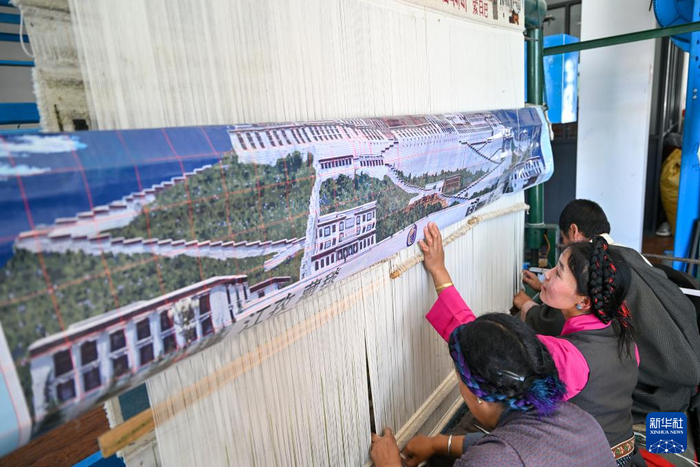 7月18日，江孜藏毯文化发展有限责任公司的员工根据电脑设计的图纸编织藏毯。