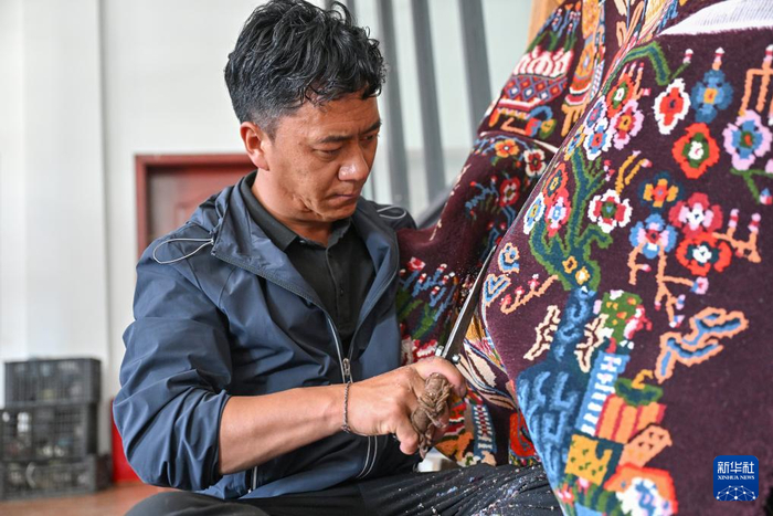 7月18日，工作人员在江孜藏毯文化发展有限责任公司内给藏毯剪花。